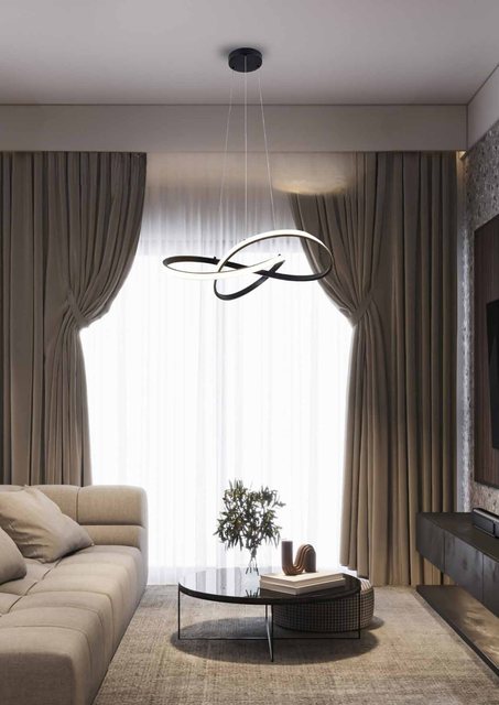 Sala de estar com cortinas claras e sofá bege, iluminada por um pendente Fita — fita de LED torcida em laço — aceso sobre a mesa de centro.