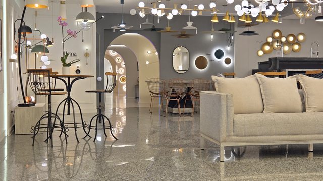 Arco do showroom da Usina, com a parede de espelhos e peças acesas