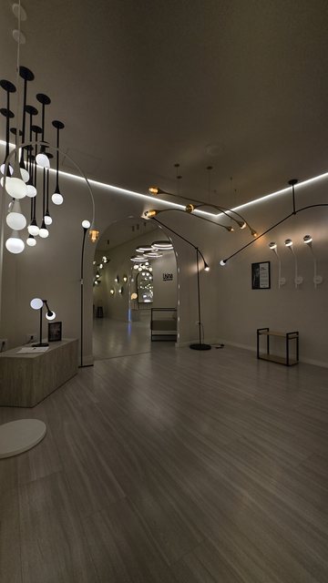 Parede de arandelas circulares acesas no showroom da Usina