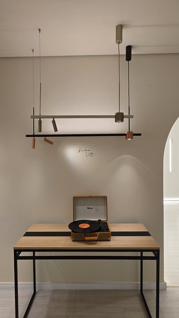 Mesa de trabalho do showroom da Usina, sob trilho de spots aceso